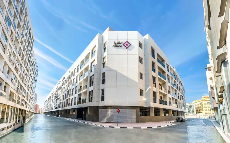 Al Ghurair residential building on a street corner under a blue sky