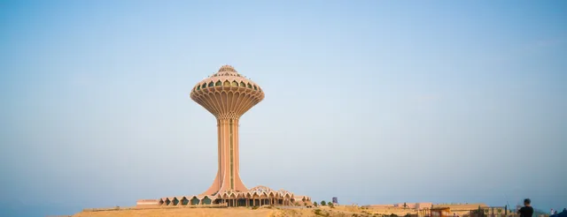 Ornate lattice tower on a raised plaza at dusk